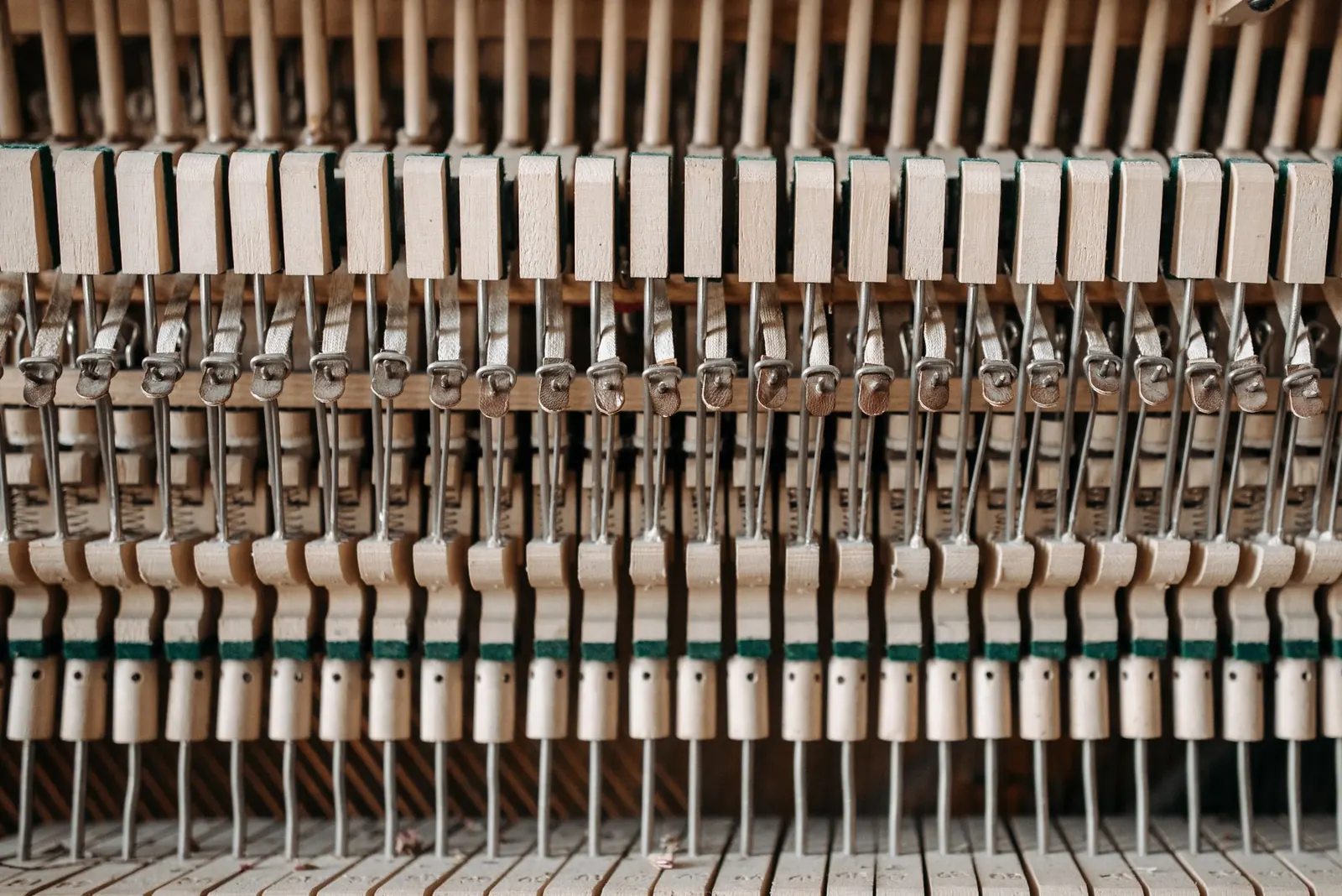 Rows of hammers and dampers inside an upright piano